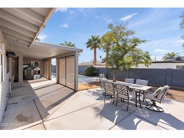 Covered patio with outdoor dining set and pool access at 1865 W Keating Ave, Mesa, AZ 85202