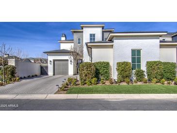 Modern two-story home with gray and white exterior, landscaped front yard, and two-car garage at 20628 E Natalie Way, Queen Creek, AZ 85142