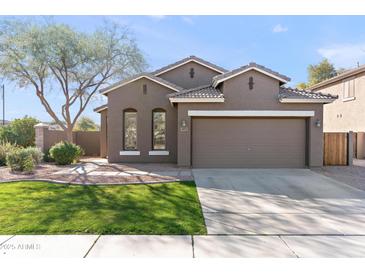 Charming single-story home with a well-manicured lawn and a two car garage at 3471 E Powell Way, Gilbert, AZ 85298