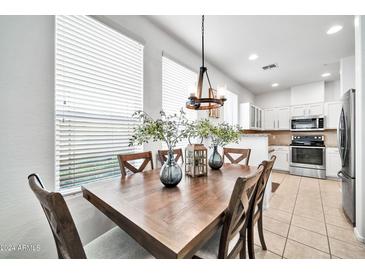 Bright dining area with wood table and chairs, adjacent to kitchen at 42424 N Gavilan Peak Pkwy # 47102, Anthem, AZ 85086