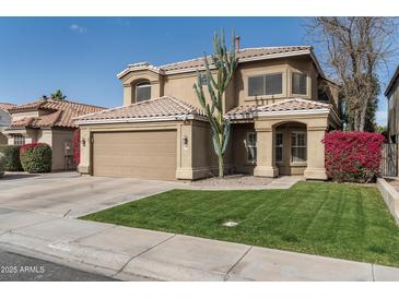 Charming home featuring a well-manicured front lawn, mature landscaping, and a two-car garage at 4760 W Tulsa St, Chandler, AZ 85226