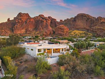 Stunning modern home with mountain views and an inviting pool with fire features at sunset at 5724 N Echo Canyon Dr, Phoenix, AZ 85018