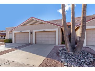 Tan two-story stucco home with two-car garage and desert landscaping at 9183 W Century Dr, Arizona City, AZ 85123