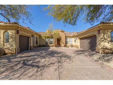 House exterior with a three car garage and mature trees at 22318 N 36Th St, Phoenix, AZ 85050