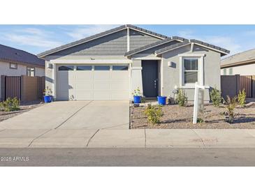 Charming single-story home featuring a two-car garage and inviting front entrance with landscaped yard at 4342 E Enmark Dr, San Tan Valley, AZ 85143