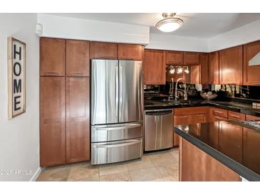 Stainless steel appliances and ample wood cabinetry in this kitchen at 4950 N Miller Rd # 130, Scottsdale, AZ 85251