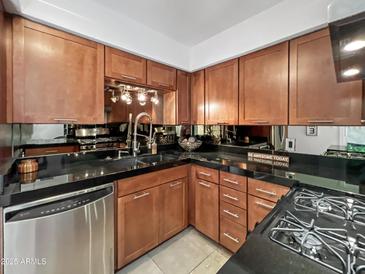 Modern kitchen with stainless steel appliances and dark countertops at 4950 N Miller Rd # 130, Scottsdale, AZ 85251