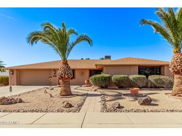 Single story home with desert landscaping and two palm trees at 12450 W Fieldstone Dr, Sun City West, AZ 85375