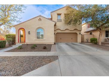 Two-story house with tan exterior, red-tiled accents, and a two-car garage at 13608 N 150Th Ln, Surprise, AZ 85379