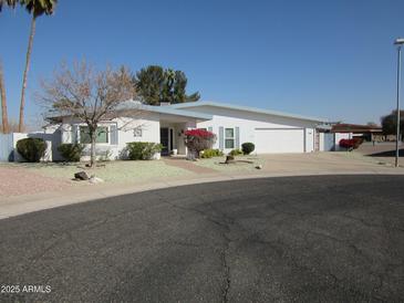 Single-story home with a large driveway and mature landscaping at 16809 N Meadow Park Dr, Sun City, AZ 85351