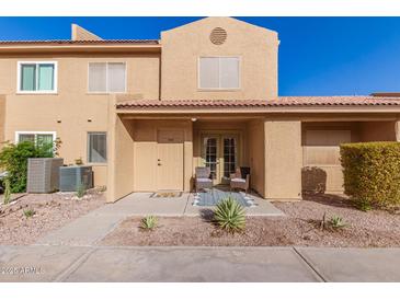 Tan two-story stucco home with front patio and two chairs at 3511 E Baseline Rd # 1206, Phoenix, AZ 85042