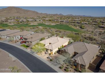 Stunning aerial view of a home on a golf course in a desert landscape with mountain views at 42225 N Celebration Way, Phoenix, AZ 85086