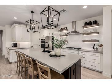 Modern kitchen with stainless steel appliances and large island with seating at 12059 N Luckenbach St, Surprise, AZ 85388