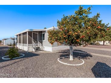 Mobile home with carport, mature landscaping, and a covered porch at 2650 W Union Hills Dr # 108, Phoenix, AZ 85027