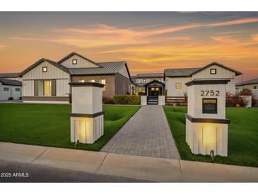 Stunning modern farmhouse with lush lawn, illuminated walkway, and charming mailbox post at sunset at 2752 E Pelican Ct, Gilbert, AZ 85297