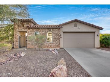 Front view of a charming one-story home with stone accents and a two-car garage at 29762 N 69Th Ln, Peoria, AZ 85383