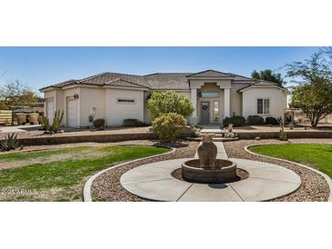 Beautiful single-story home featuring a well-manicured lawn, a water fountain, and a three-car garage at 3791 E Vista Grande Dr, San Tan Valley, AZ 85140