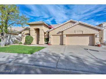 Charming single-story home featuring a three-car garage and well-manicured front yard at 5184 W Del Rio St, Chandler, AZ 85226