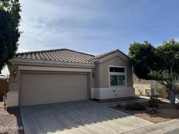 Tan one-story house with a two-car garage and landscaping at 5829 E Nora St, Mesa, AZ 85215