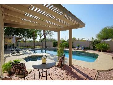 Inviting backyard with a sparkling pool, pergola, and patio furniture at 14644 N 7Th Pl, Phoenix, AZ 85022