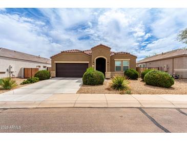 Charming home featuring a well-manicured front yard with low maintenance desert landscaping and a two-car garage at 41917 W Manderas Ln, Maricopa, AZ 85138