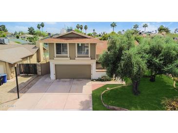 Two-story home featuring an attached garage, well-maintained lawn, and mature tree in a quiet neighborhood at 4615 W Boston St, Chandler, AZ 85226