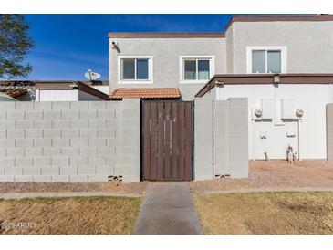 Back exterior view of townhome with private gated entry and small yard at 954 E Diamond Dr, Tempe, AZ 85283