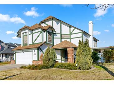 Two-story house with a white exterior, green accents, and a brick facade at 1112 W Citation Dr, Chandler, AZ 85224