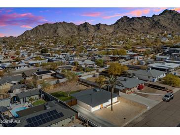 Aerial view of a single-story house with a pool, solar panels, and mountain backdrop at 1510 E Mission Ln, Phoenix, AZ 85020