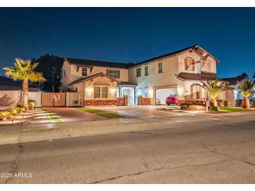 Two-story house with a red car parked in the garage at night at 16846 W Hilton Ave, Goodyear, AZ 85338