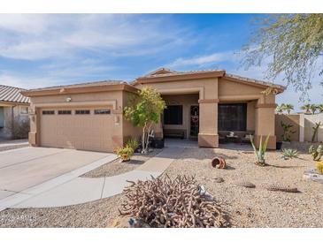 Single-story home with desert landscaping, two-car garage, and covered entryway at 17581 W Canyon Ln, Goodyear, AZ 85338