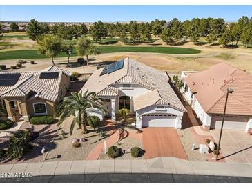 Attractive single-story home with desert landscaping, solar panels, and a two-car garage, set on a golf course lot at 17906 N Encanto Dr, Surprise, AZ 85374