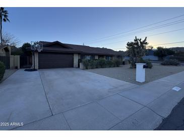 Ranch-style home with a two-car garage and landscaped front yard at 2401 E Christy Dr, Phoenix, AZ 85028