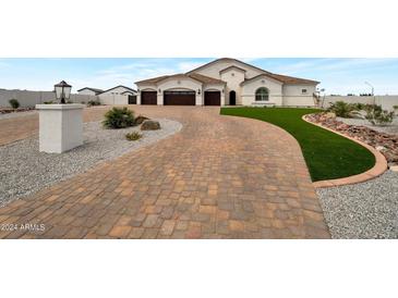 Elegant two-story home with a three-car garage and landscaped front yard at 25232 S Pyrenees Ct, Queen Creek, AZ 85142