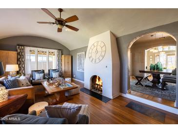 Inviting living room with a cozy fireplace, hardwood floors, and an open archway to dining at 537 W Encanto Blvd, Phoenix, AZ 85003