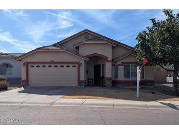 Charming single-story home with a two car garage, covered entryway, and manicured front yard at 7417 W Park St, Laveen, AZ 85339