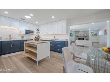 Modern kitchen boasts updated appliances and an island with seating at 8413 E Sheridan St, Scottsdale, AZ 85257