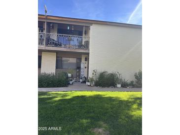 Inviting condo exterior with well-manicured lawn and balcony at 1550 N Stapley Dr # 35, Mesa, AZ 85203
