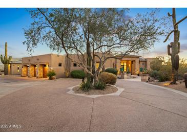 Stunning desert home with circular driveway, mature trees, and landscape lighting at 23238 N 94Th Pl, Scottsdale, AZ 85255