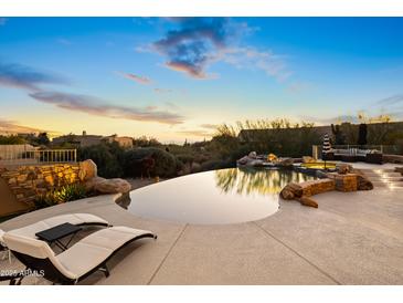 Luxury backyard oasis featuring a large infinity pool, spa, and fire pit at 23238 N 94Th Pl, Scottsdale, AZ 85255