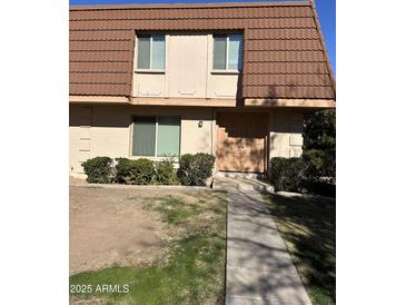 Tan brick condo building with brown tile roof, double door entry, and small front yard at 1631 E Logan Dr, Tempe, AZ 85282