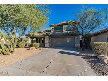 Two-story house with a large driveway and landscaping at 2438 W Gambit Trl, Phoenix, AZ 85085