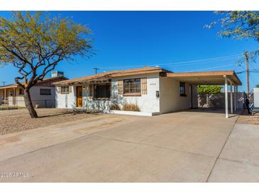 Charming single-story home features a carport, desert landscaping and neutral paint at 2906 W Alice Ave, Phoenix, AZ 85051