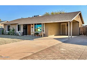 Charming single-story home with a well-maintained front yard, covered parking, and a welcoming entrance at 4903 W Palm Ln, Phoenix, AZ 85035