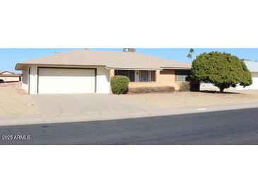 Ranch-style home with a two-car garage and mature landscaping at 9714 W Edward Dr, Sun City, AZ 85351