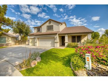 Two-story house with a three-car garage and well-maintained lawn at 7605 S 18Th Way, Phoenix, AZ 85042