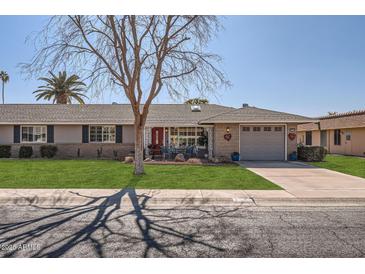 Ranch-style home with gray garage door and well-manicured lawn at 9613 W Long Hills Dr, Sun City, AZ 85351