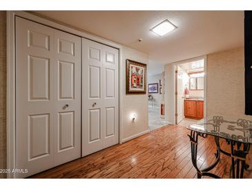 Bright hallway with wood floors, leading to bathroom and closets at 10330 W Thunderbird Blvd # A321, Sun City, AZ 85351