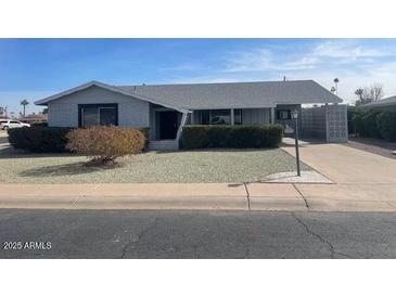 Ranch style home with a well-manicured lawn and a long driveway at 10365 W Pinehurst Dr, Sun City, AZ 85351