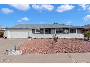 White brick ranch house with gray roof and attached garage at 10531 W Prairie Hills Cir, Sun City, AZ 85351